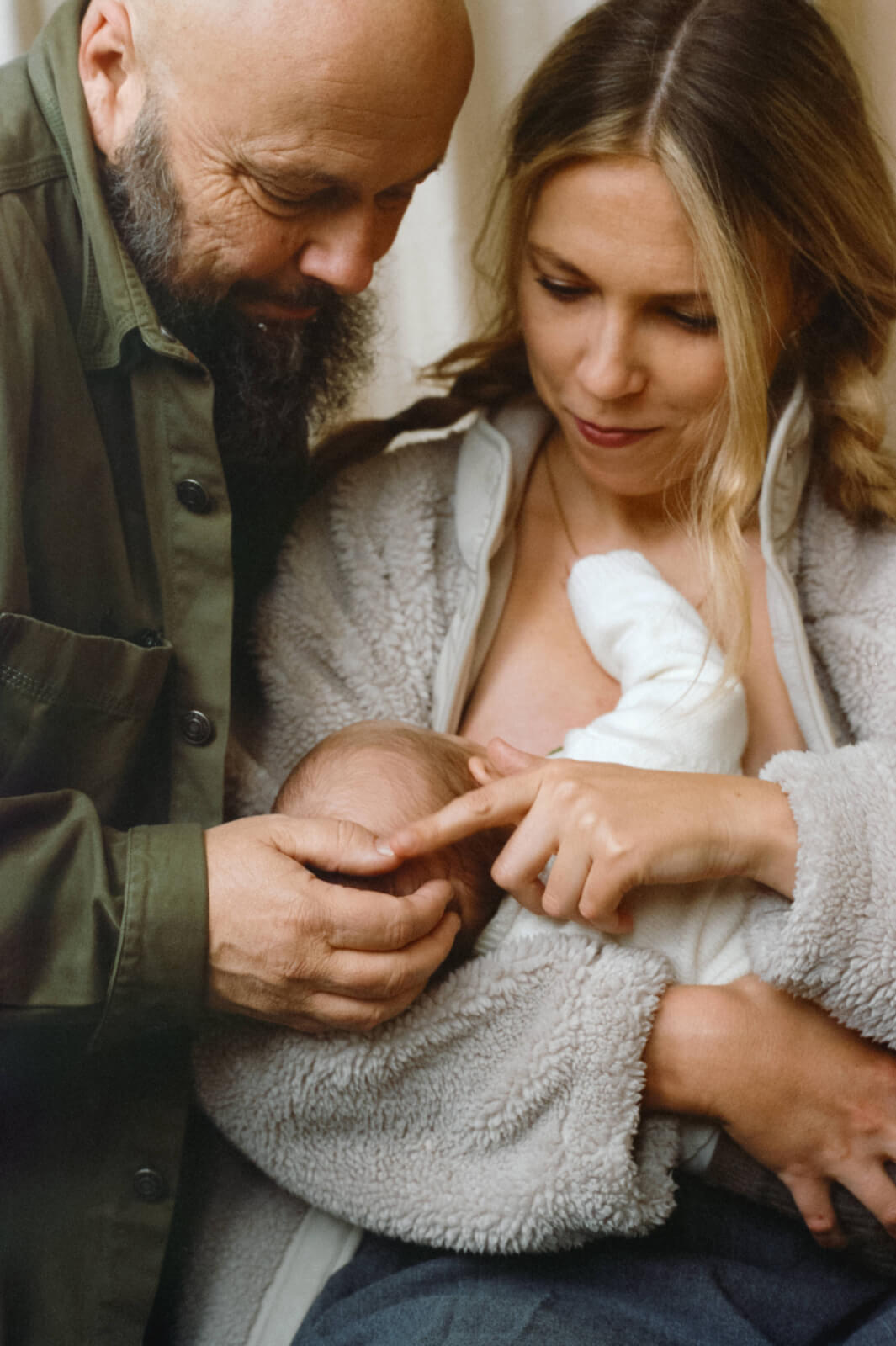 un couple avec leur nouveau-né dans les bras de la maman qui allaite