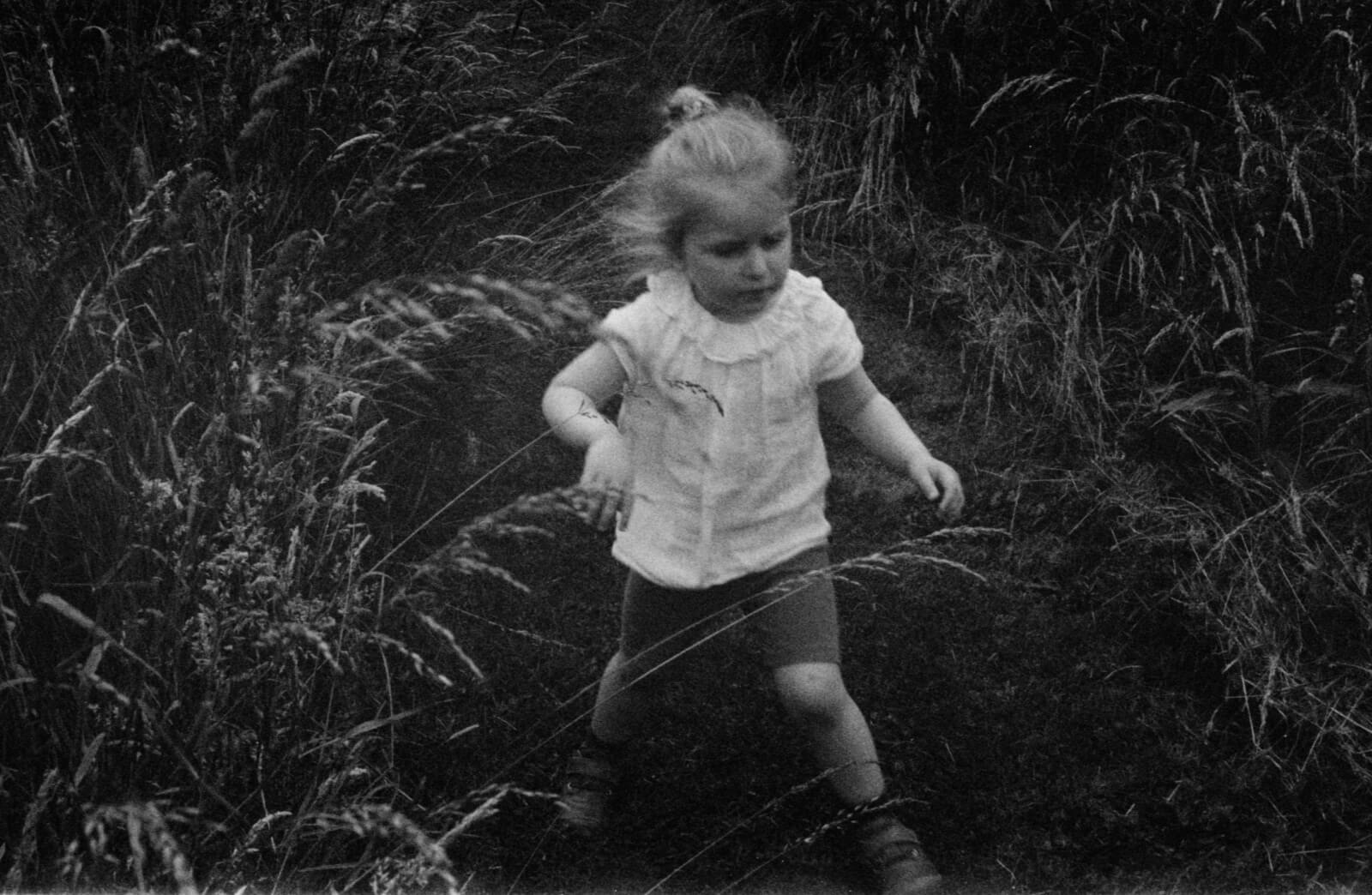 une enfant court dans l'herbe