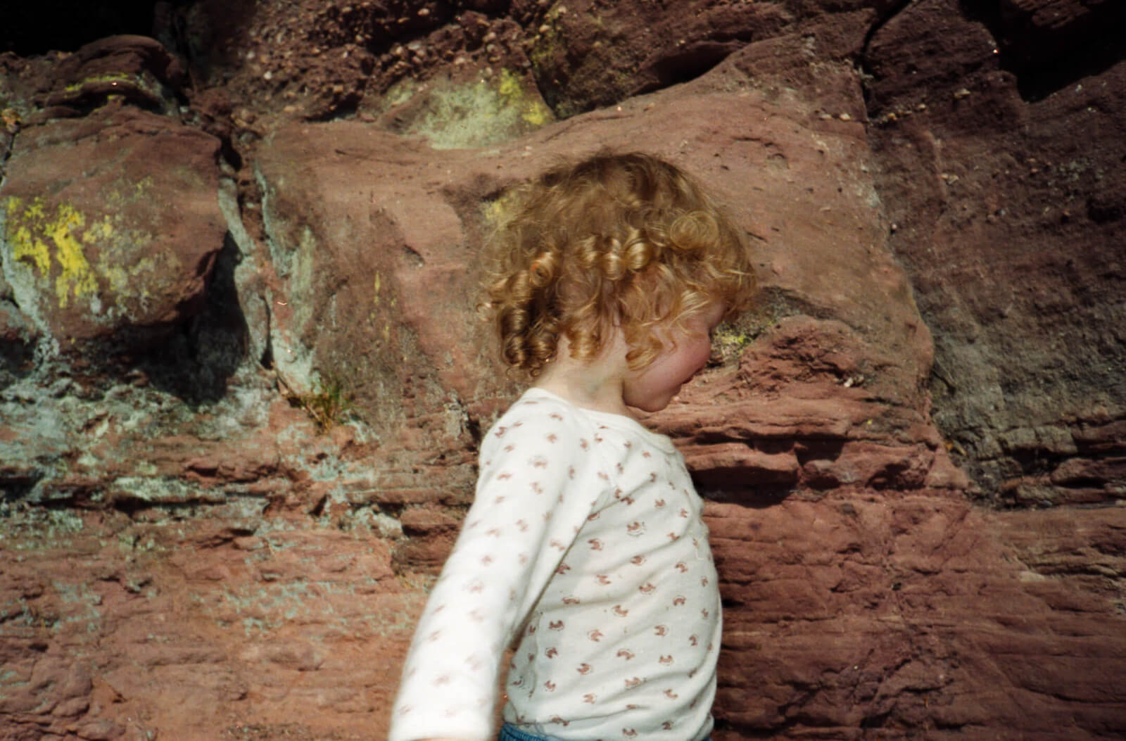 un enfant se tient devant la roche