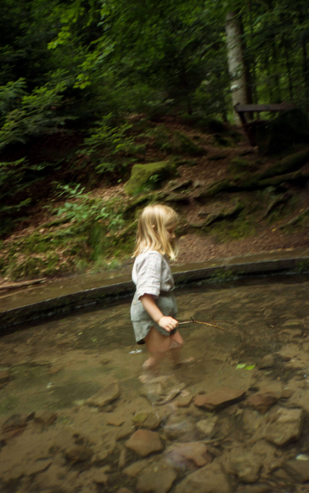 enfant qui marche les pieds dans l'eau dans une fontaine