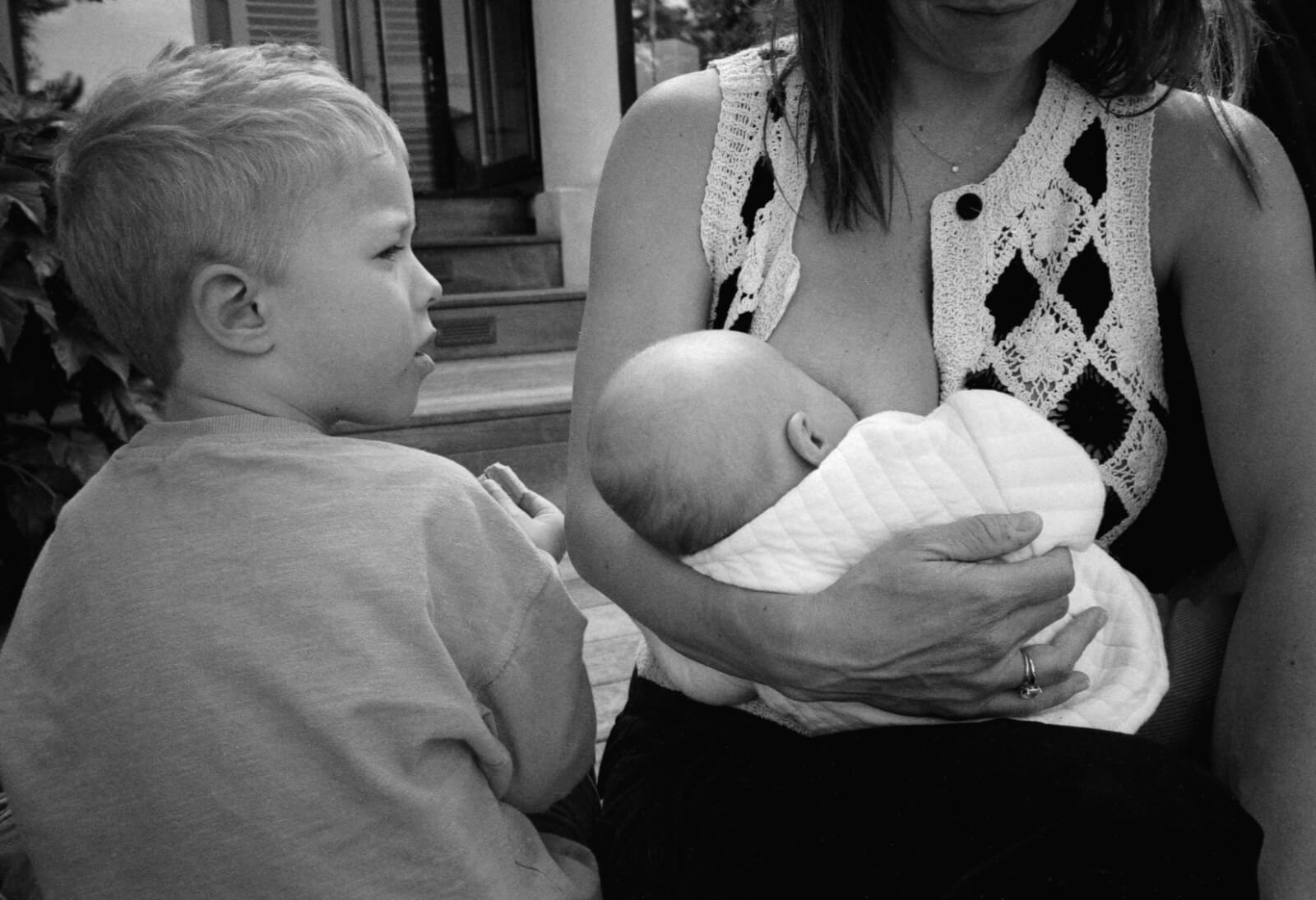 une maman allaite son bébé, assise avec son fils plus grand à côté d'elle