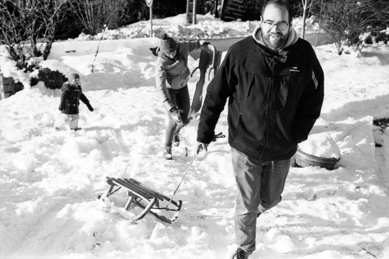 une famille fait de la luge dans la neige dan les Vosges