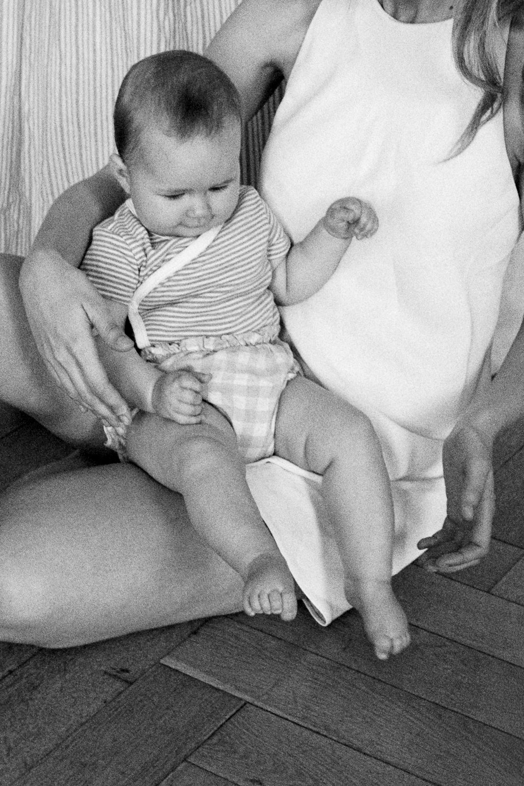un bébé sur les genoux de sa maman lors d'une séance photo pour la fête des mères